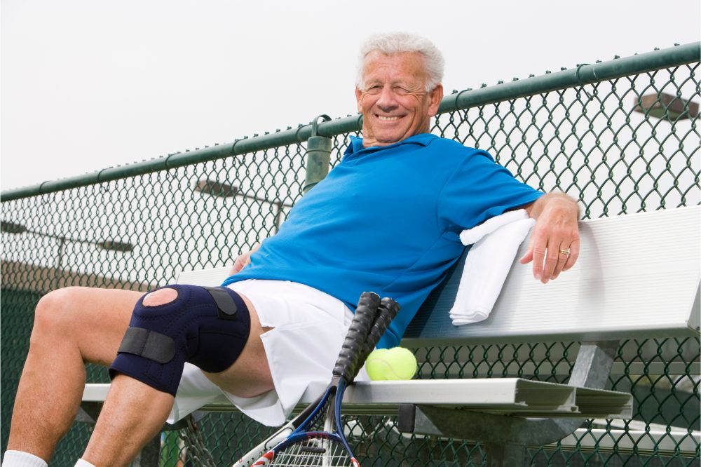 senior man relaxing on bench after playing tennis